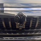 Close-up of a glossy black chrome front grille emblem for a luxury vehicle.