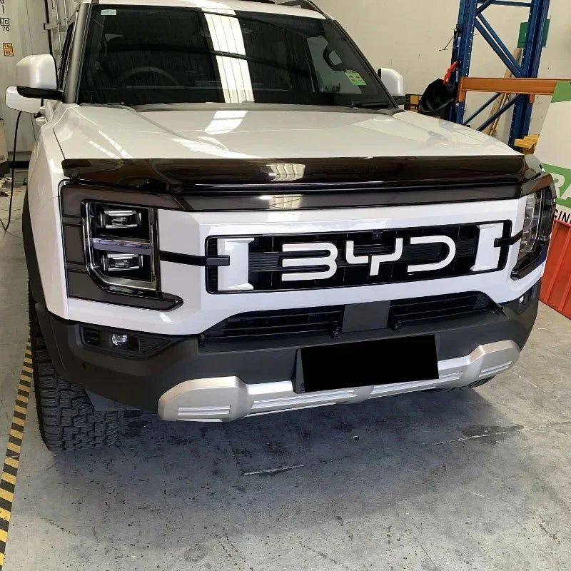 White BYD SUV featuring a sleek black front grille guard and rugged silver bumper protector.