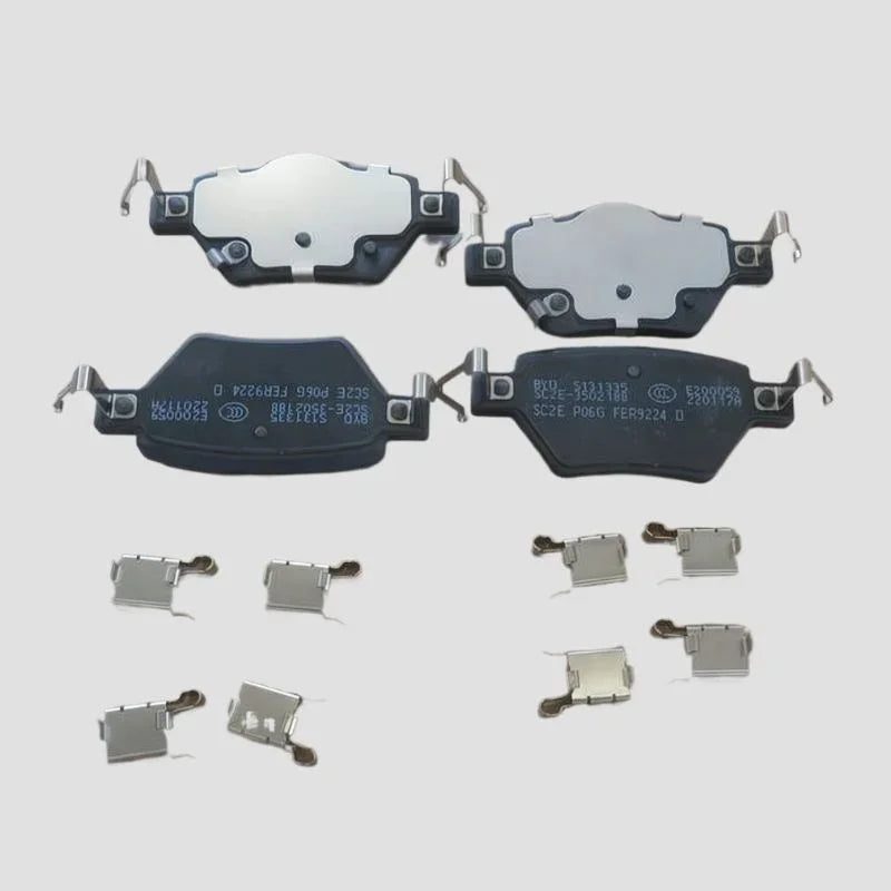 Set of four black and silver metal ceramic brake pads with hardware clips