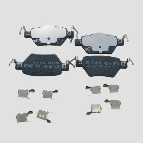 Set of four black and silver metal ceramic brake pads with hardware clips