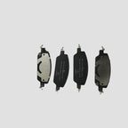 Four professional-grade black and silver metal brake pads for automotive braking systems.