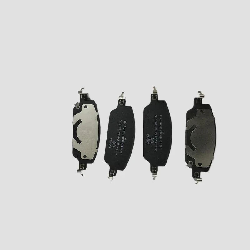 Four professional-grade black and silver metal brake pads for automotive braking systems.
