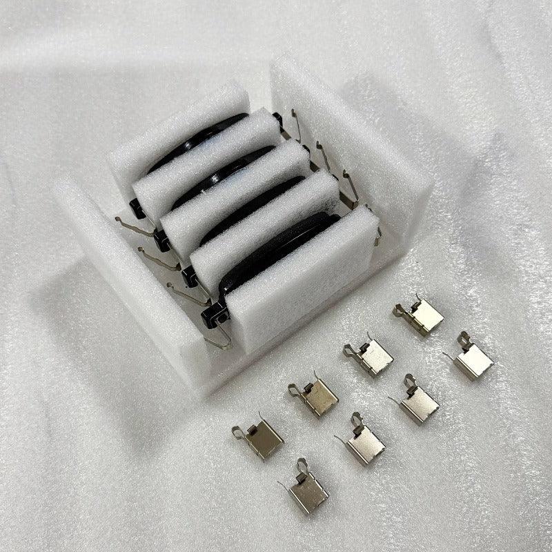 Set of four black car door handles with metal clips in protective white foam packaging.