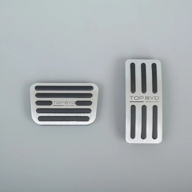 Silver brushed metal car pedal covers with black anti-slip rubber strips.