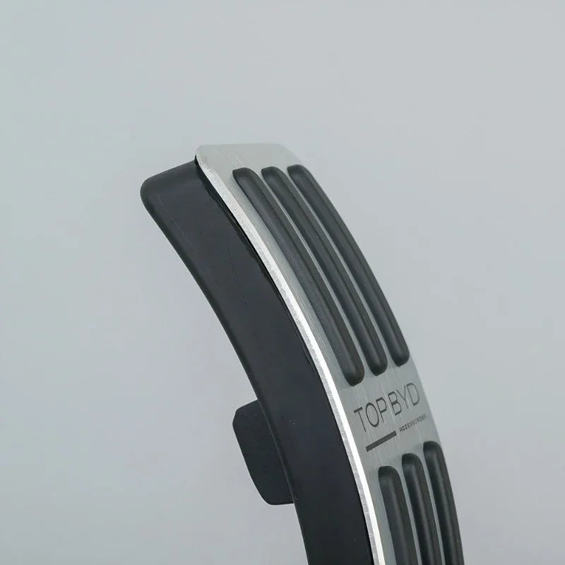 Black rubber and silver metal anti-slip car pedal accessory with textured grip.