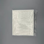 White pleated cabin air filter in protective clear plastic packaging.