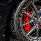 High-performance Yokohama tire paired with a sleek grey alloy rim and bright red brake caliper.