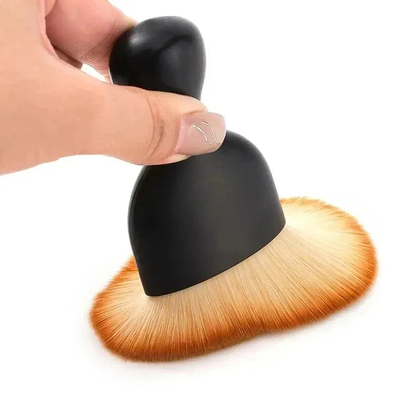 Professional black matte makeup brush with soft orange-tinted synthetic bristles.