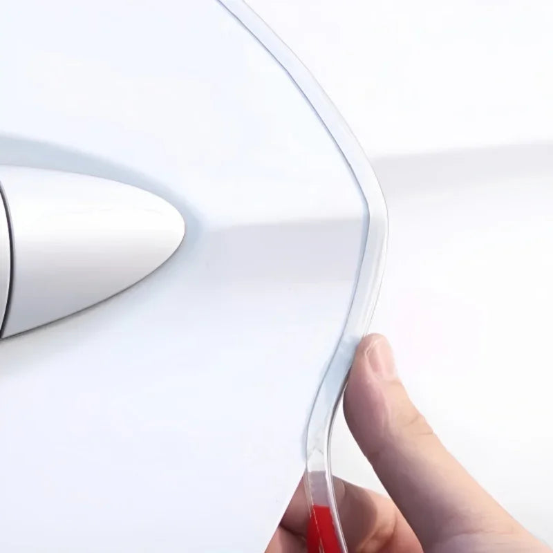 Clear transparent protective film being applied to a white car door edge