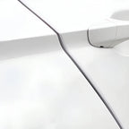 Close-up of a white automotive door handle and sleek body panel seam.