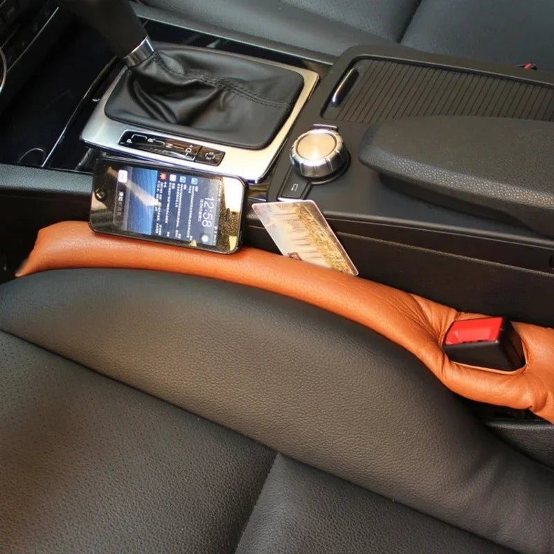 Brown leather seat belt cover protecting black car interior upholstery.