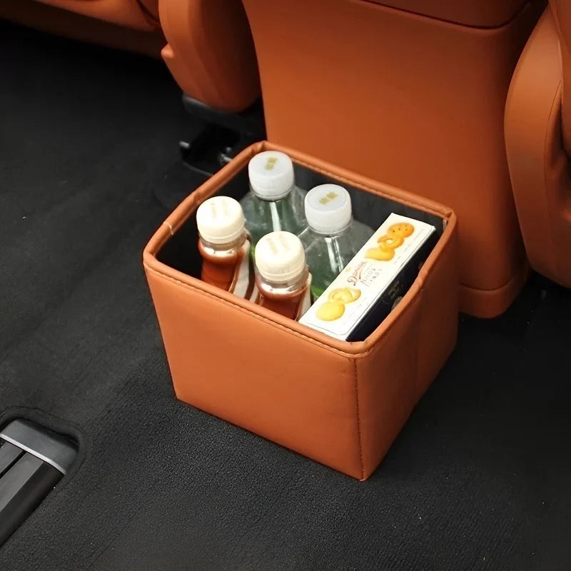 Brown faux leather car seat gap organizer holding water bottles and snacks.