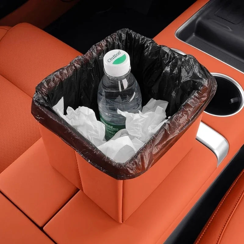 Orange faux leather car trash bin with black liner containing a water bottle and tissues