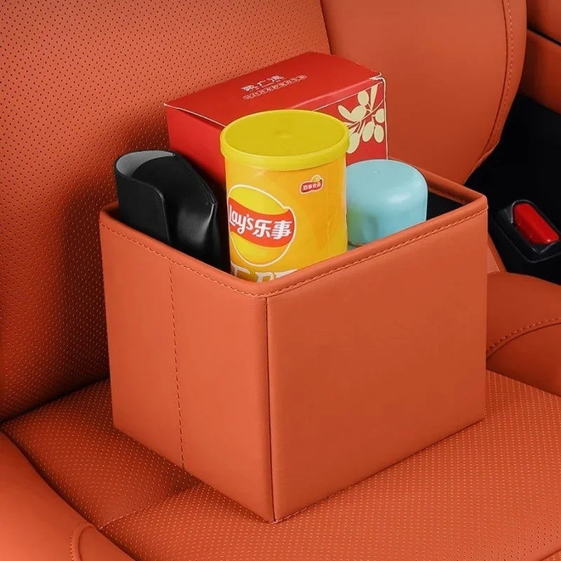 Brown leather car seat gap organizer holding snacks and items, matching orange interior.