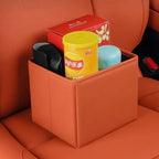 Brown leather car seat gap organizer holding snacks and items, matching orange interior.
