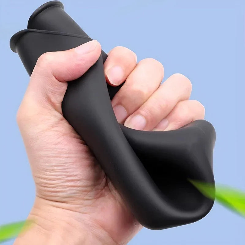 A hand squeezing a flexible black silicone material, demonstrating its soft and durable texture.