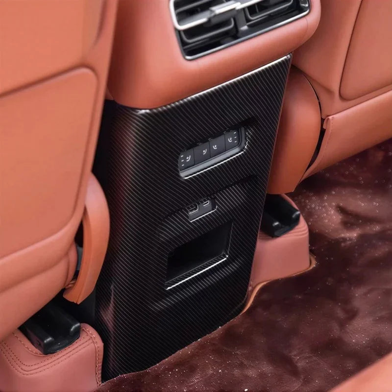Carbon fiber rear seat center console trim in black, paired with brown leather interior.
