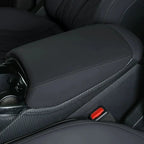Black leather center console armrest with carbon fiber trim accents