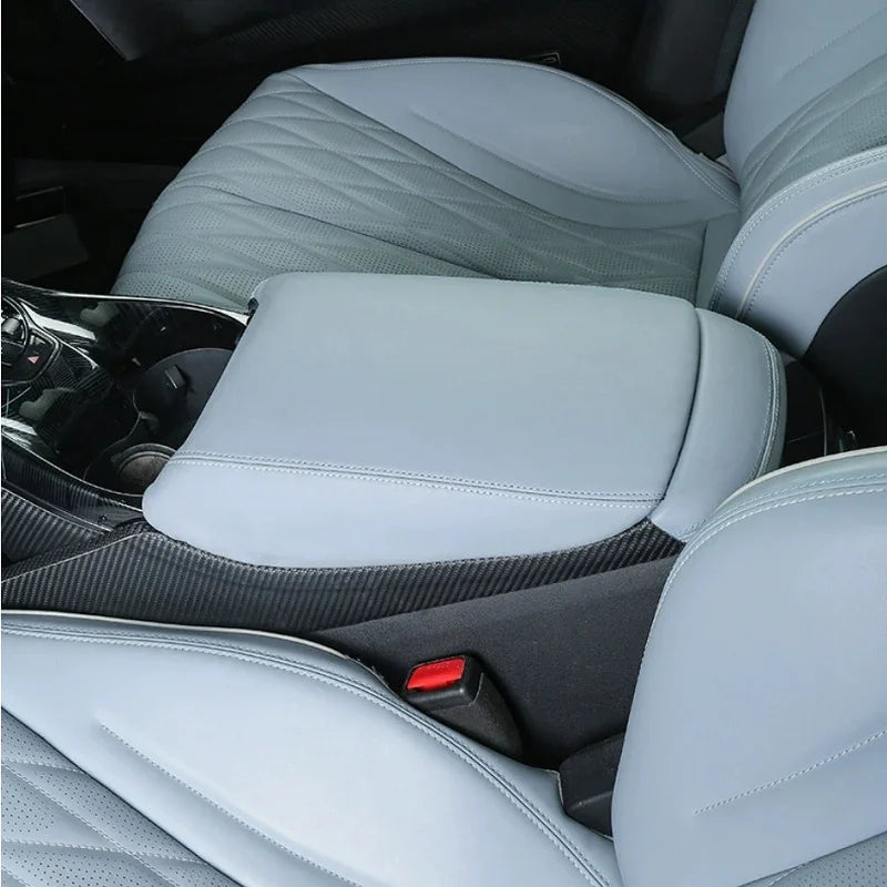 Light grey quilted leather center armrest cover with carbon fiber texture trim.