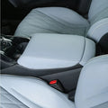 Light grey quilted leather center armrest cover with carbon fiber texture trim.