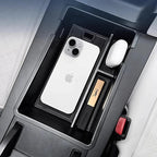 Black carbon fiber center console organizer for BYD featuring a white iPhone and wireless earbuds.