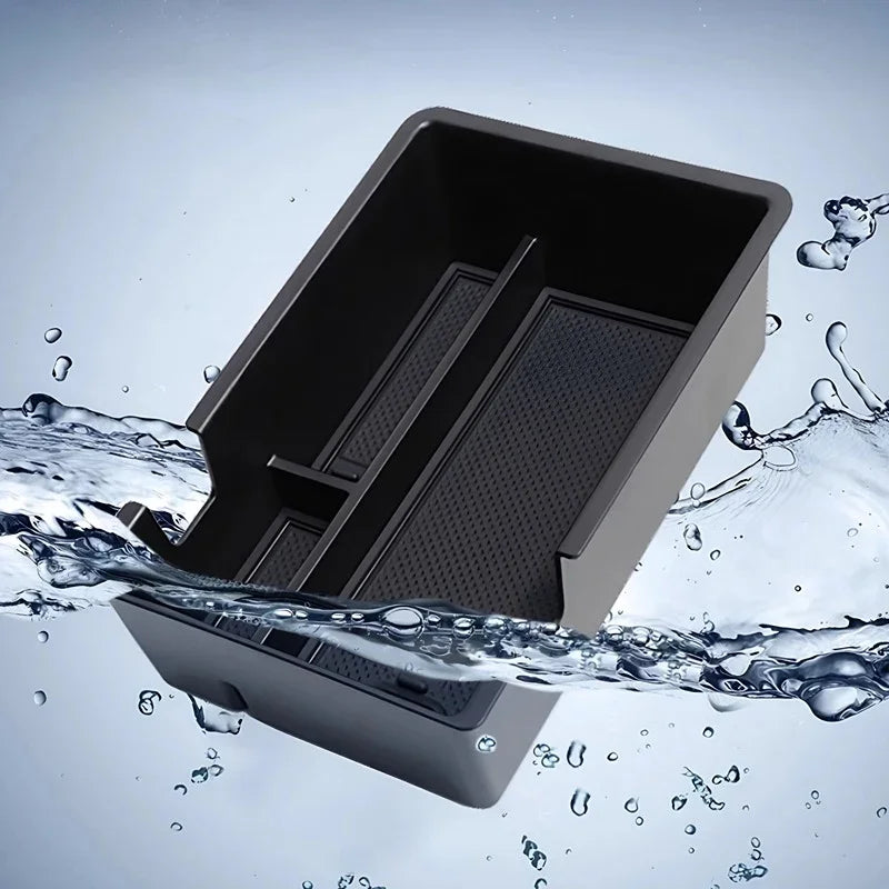 Black durable plastic organizer tray with a textured bottom, shown partially submerged in splashing water.