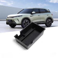 Black durable plastic center console organizer tray for a modern white BYD electric vehicle.