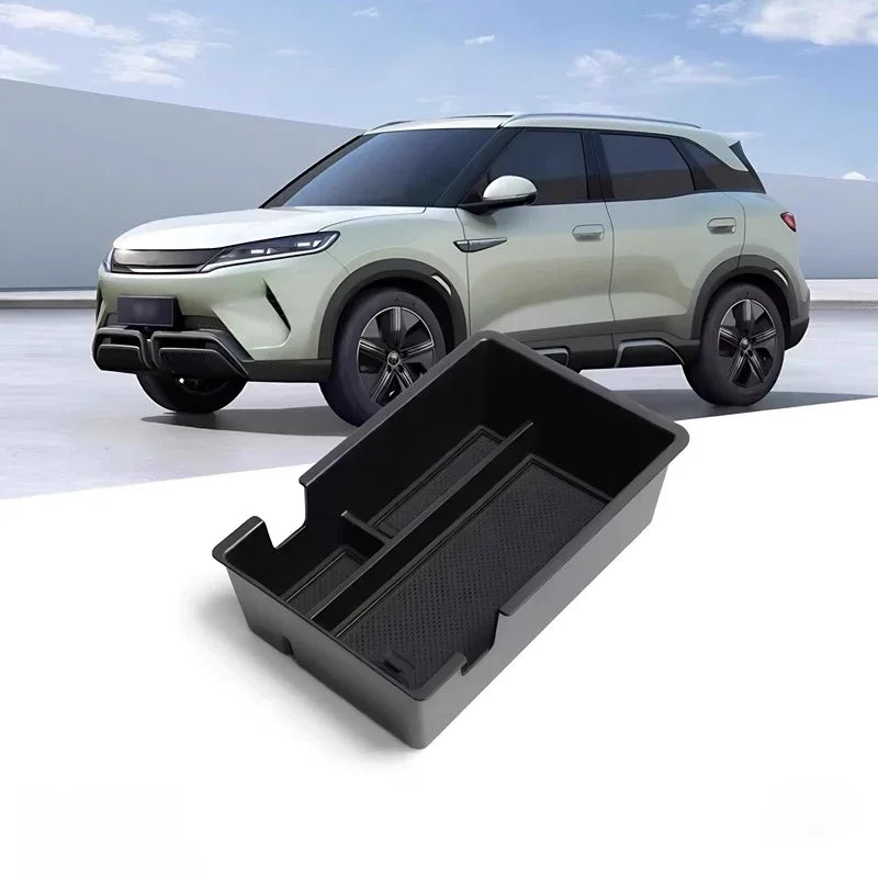 Black durable plastic center console organizer tray for a modern white BYD electric vehicle.
