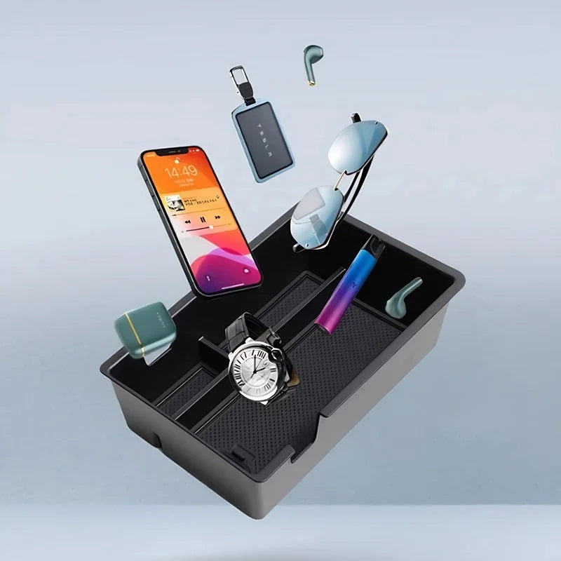 Black textured organizer tray holding a smartphone, sunglasses, watch, and wireless earbuds.