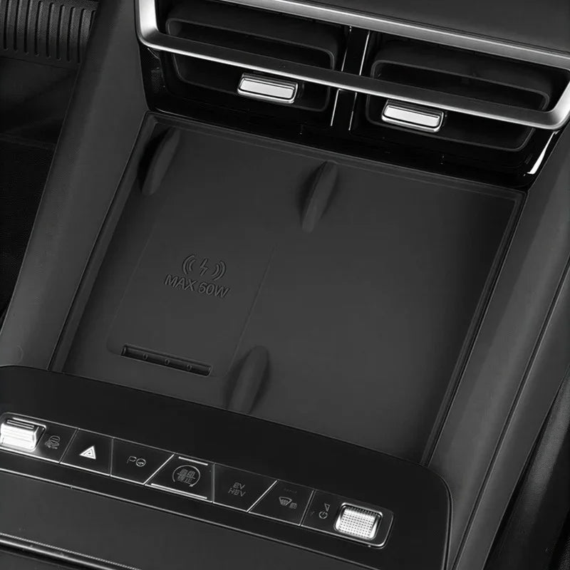 Black wireless charging pad with MAX 60W icon integrated into a car center console.