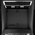 Black matte wireless charging pad with 50W max power icon in a car center console.