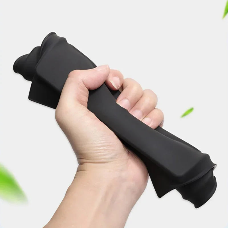 A hand gripping a flexible black silicone protective mat designed for durability.