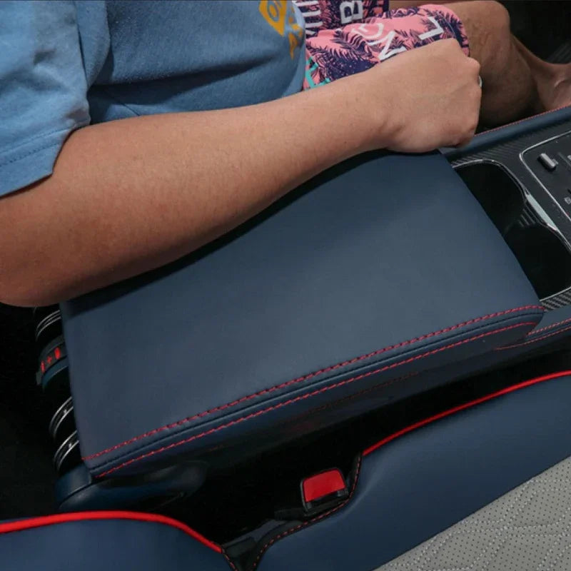 Navy blue leather center armrest cover with sporty red contrast stitching for BYD car interior.