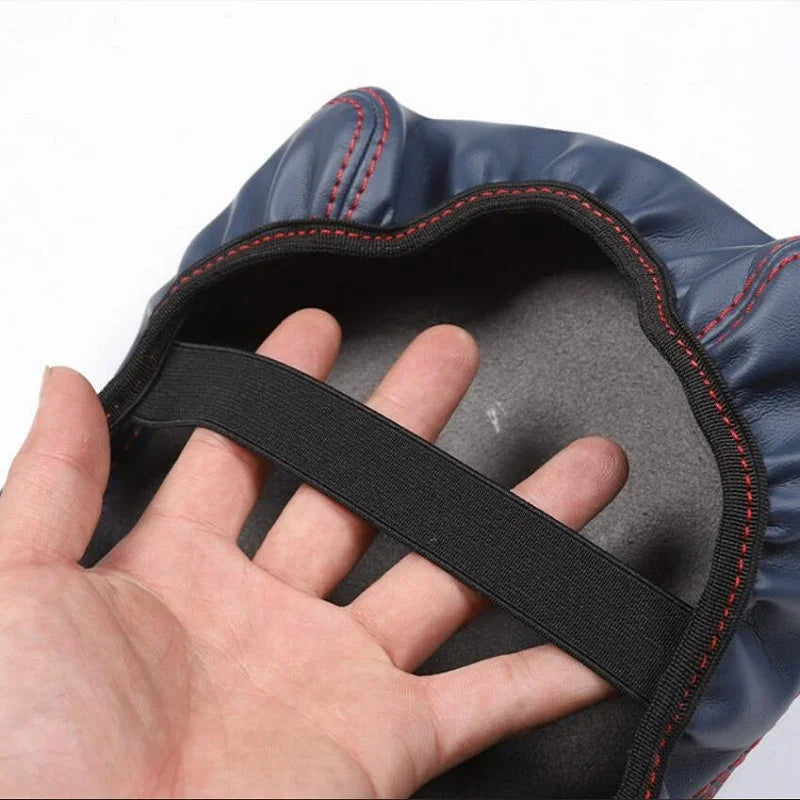 Close-up of a navy blue leather car accessory with contrasting red stitching and black elastic band.