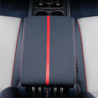 Navy blue leather center console armrest with a bold red stripe and contrast stitching.