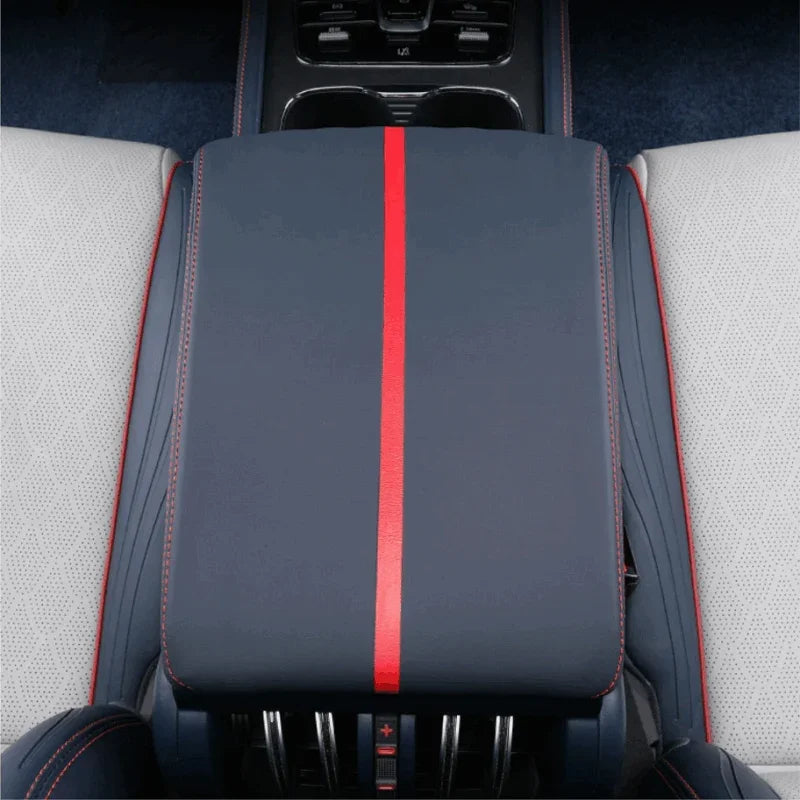 Navy blue leather center console armrest with a bold red stripe and contrast stitching.