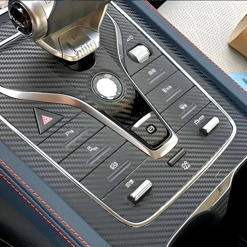 Carbon fiber pattern center console trim with silver accents and red stitching detail.