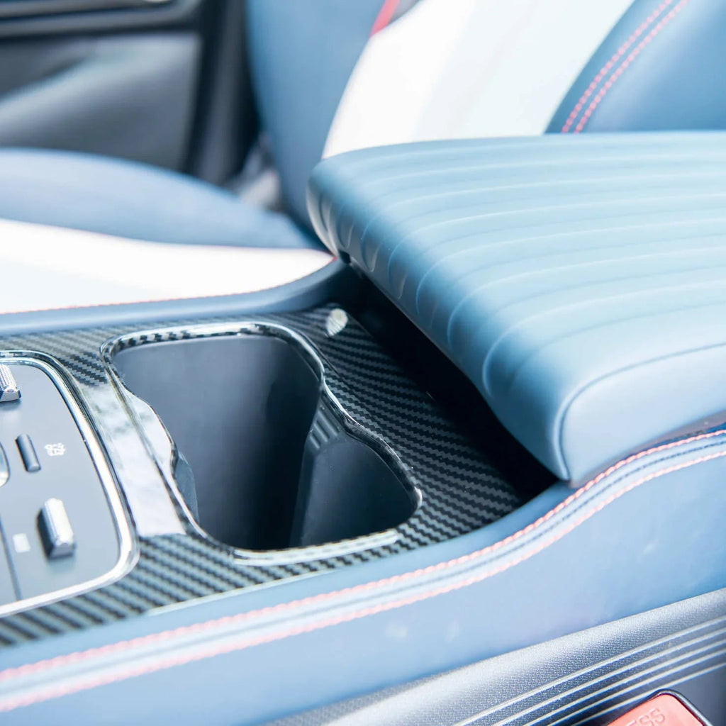 Blue leather car center console with carbon fiber cupholder trim and red stitching