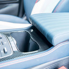 Blue leather car center console with carbon fiber cupholder trim and red stitching