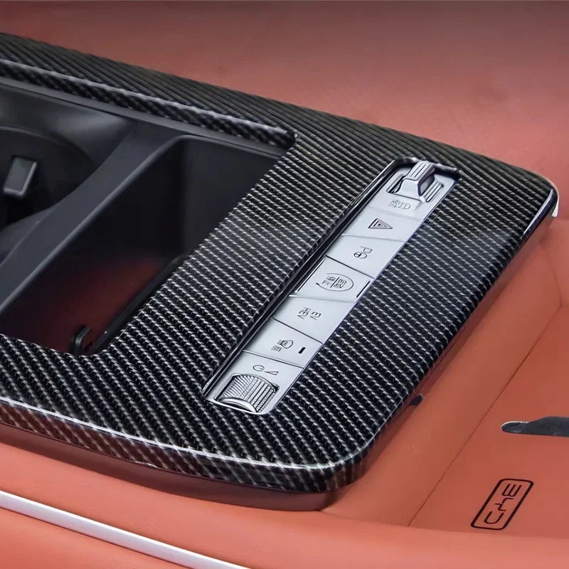 Black carbon fiber center console trim with integrated control buttons for BYD interior enhancement.