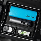 Blue textured leather organizer and grey metallic thermos in a black car storage compartment.
