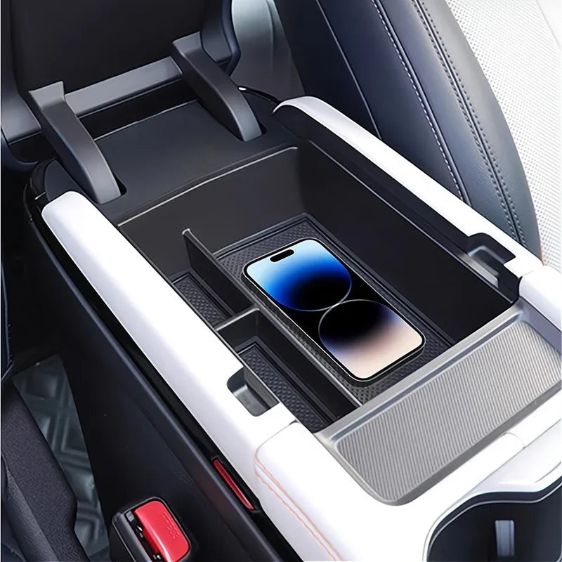 Black carbon fiber texture center console organizer tray with a smartphone inside.