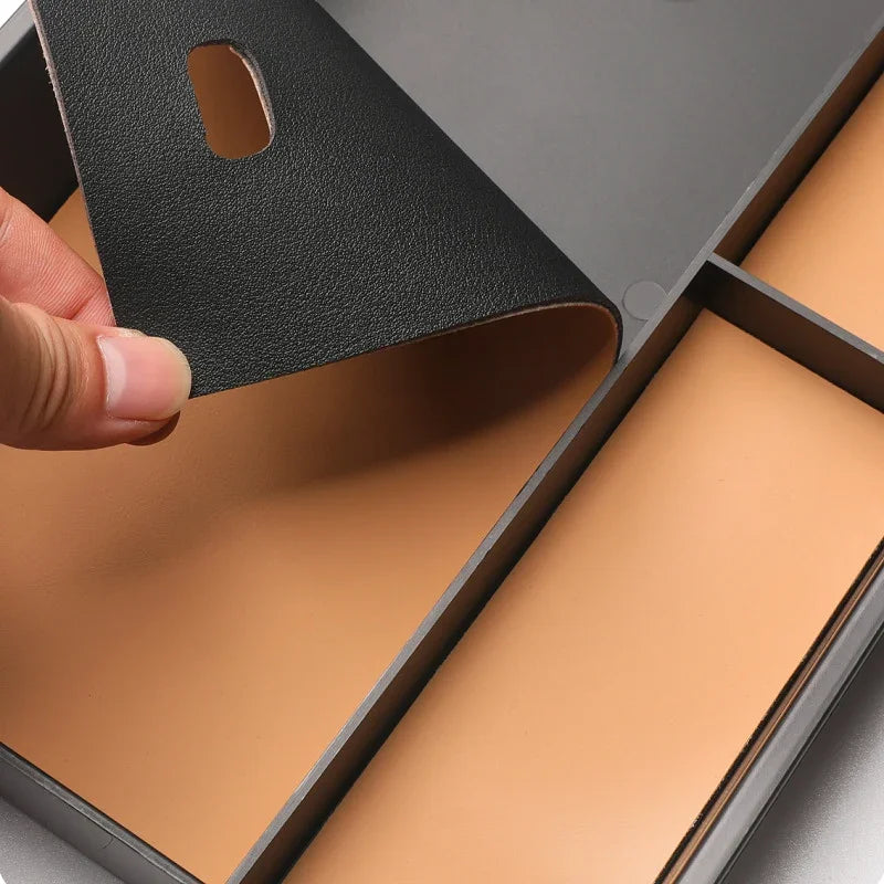 Close-up of a black textured leatherette car organizer liner revealing a brown interior.