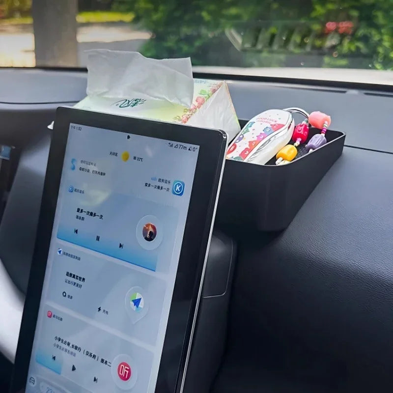 Black matte plastic car organizer tray holding tissues and small accessories next to a BYD tablet.