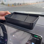 Matte black textured organizer tray for car dashboard storage.