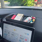 Black matte organizer tray holding a red power bank and small accessories on a car dashboard.