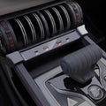 Close-up of a modern car interior featuring a sleek black center console with USB ports and a grey gear shifter.