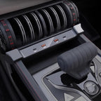 Close-up of a modern car interior featuring a sleek black center console with USB ports and a grey gear shifter.