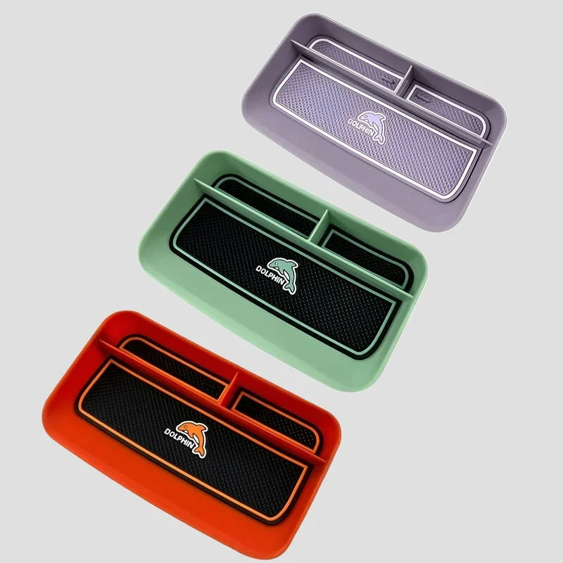 Three colorful BYD Dolphin center console organizer trays in purple, mint green, and orange.