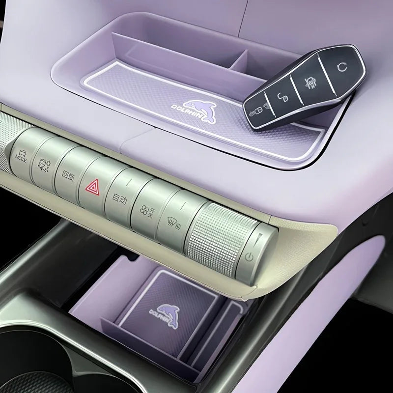 Light purple BYD Dolphin interior with silver metallic control buttons and car key in tray.